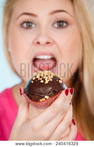 Diet, Sweets, Food Concept. Woman Holding Delicious Chocolate Cupcake With Peanut Frosting, Having W