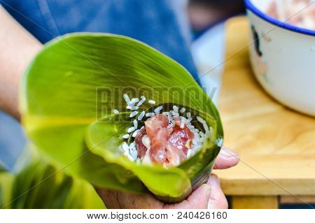 Chinese Making Zongzi. Hand Holding Leaf Filled By Sticky Rice & Pork. Zongzi Is Traditional Chinese