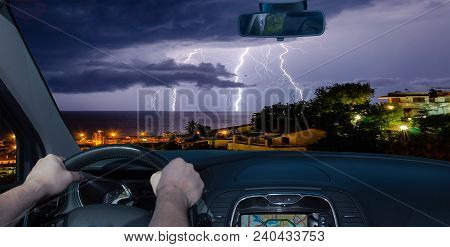 Driving A Car Towards A Spectacular Lightning Storm Over The Sea