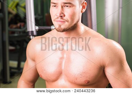 Mixed Race Man Is Working Out On Butterfly Machine In Gym.