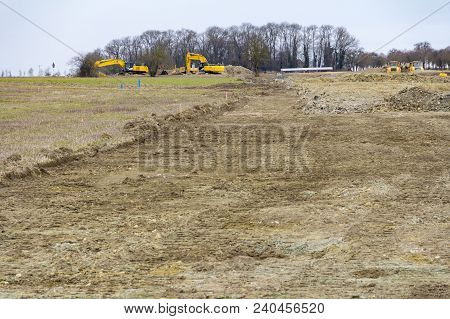 Excavators And Other Construction Machines At A Loamy Construction Site