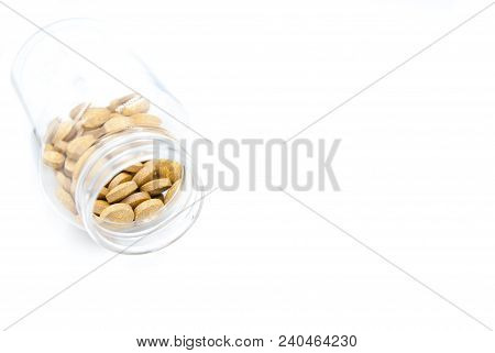 Dropped Container And Yellow Pills On White Background