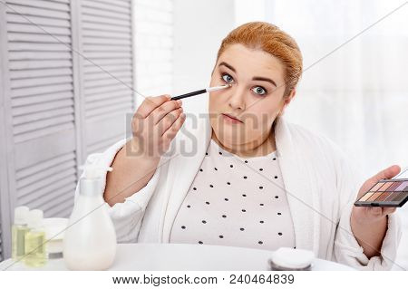 My Hobby. Serious Fat Woman Wearing A Bathrobe And Applying Make-up