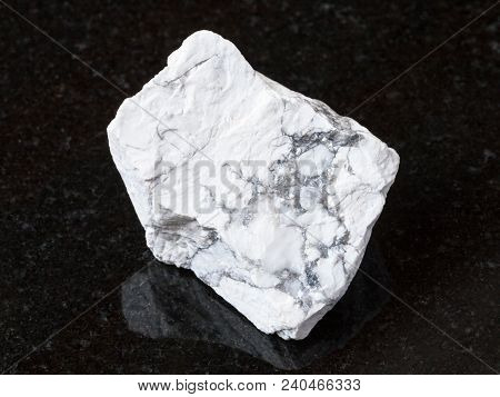 Macro Shooting Of Natural Rock Specimen - Raw Howlite Stone On Black Granite Background