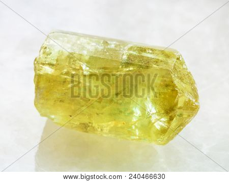 Macro Shooting Of Natural Rock Specimen - Raw Crystal Of Yellow Apatite Gemstone On White Marble Bac