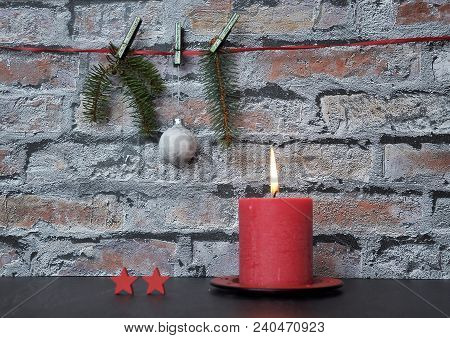 Colorful And Crisp Image Of Burning Candle And Christmas Decoration In Front Of Brick Wall