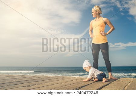 Baby Boy Playing With Mother On The Beach, Summer Day. Supermom With Toddler Son Learning To Walk On