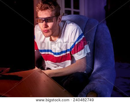 Young Man Sitting On The Sofa Wathing Tv Film At Home Using 3d Glasses