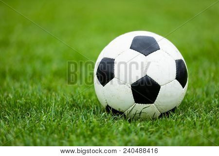 Classic Soccer Football Ball On Soccer Pitch. Green Grass Soccer Field. Soccer Turf In The Backgroun
