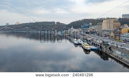 View of the pedestrian bridge, the Vladimirskaya Hill with the monument of the Arco-Soviet of the People, the river Dnipro and tourist parades in Kyiv