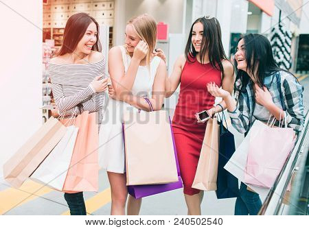 A Picture Of Happy And Satisfied Women Going Together. They Are In Store. Girls Are Looking At Each 