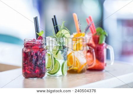 Various Lemonades In Mason Jars With Orange Lime Lemon Otange Strawberries And Fresh Fruit Fruits