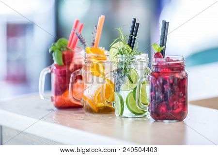 Various Lemonades In Mason Jars With Orange Lime Lemon Otange Strawberries And Fresh Fruit Fruits