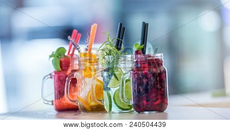 Various Lemonades In Mason Jars With Orange Lime Lemon Otange Strawberries And Fresh Fruit Fruits
