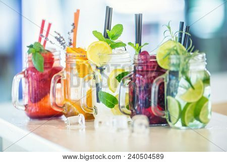 Various Lemonades In Mason Jars With Orange Lime Lemon Otange Strawberries And Fresh Fruit Fruits