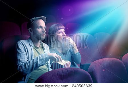 Teenager couple cuddling and watching the climax part of the movie