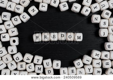 Word Fredom On Wooden Cubes On A Black Wooden Table With Copy Space