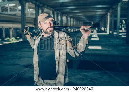Calm And Peaceful Commandor Is Standing And Posing. He Is Looking Aside. Also Guy Has A Rifle In His