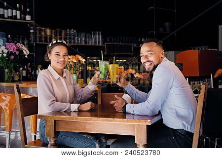 Black American Couple Talks And Drinks, Fresh Juice At A Cafe