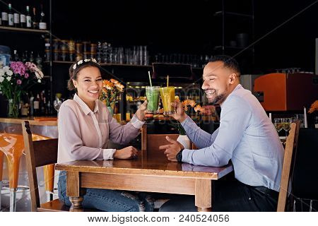 Black American Couple Talks And Drinks, Fresh Juice At A Cafe