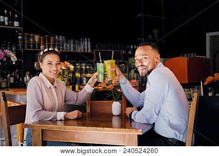 Black American Couple Talks And Drinks, Fresh Juice At A Cafe