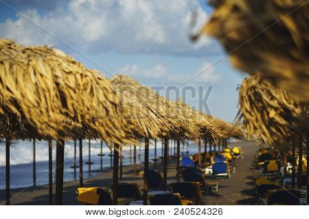 Vacation, Travel, Beach And Beach Umbrellas From The Straw During The Tide. Sea Waves And Empty Sand