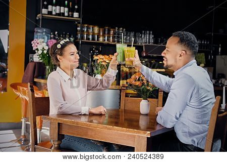 Black American Couple Talks And Drinks, Fresh Juice At A Cafe