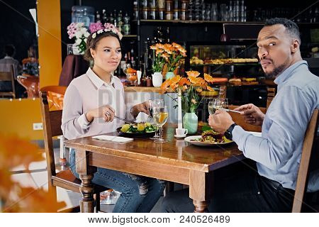 Black American Male And Female Eating Vegan Food In A Restaurant.