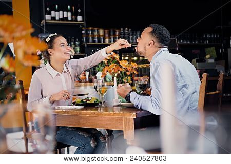 Black American Male And Female Eating Vegan Food In A Restaurant.