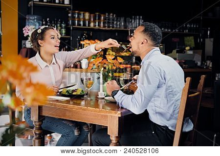 Black American Male And Female Eating Vegan Food In A Restaurant.
