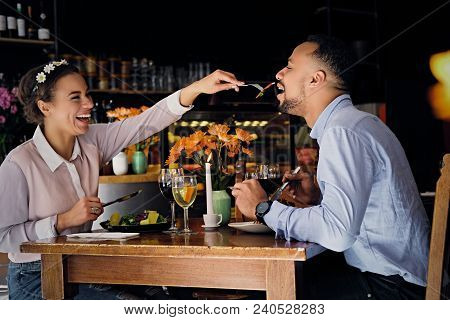 Black American Male And Female Eating Vegan Food In A Restaurant.