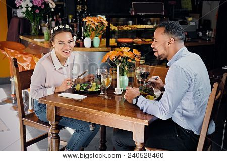 Black American Male And Female Eating Vegan Food In A Restaurant.