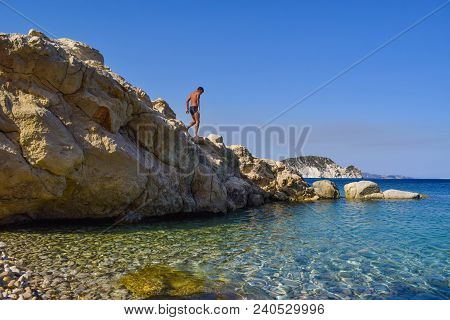 The Boy On The Rock In Sea. Marathias Beach, Zakynthos Island, Greece.