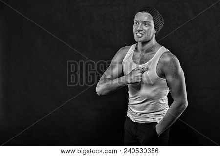 Macho On Aggressive Face With Strong Muscles Look Brutal, Black Background. Man With Muscular Arms P