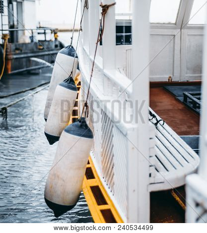 Vertical Side View Of A Wooden Boat For An Underwater Diving With Multiple Buoys On It; The Wooden F