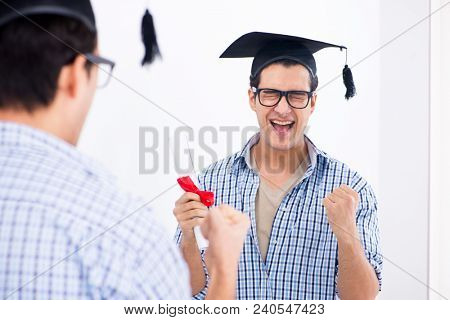 Young student planning graduation speech in front of mirror
