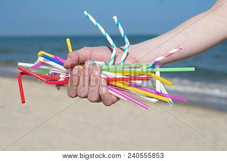 Close Up Of Hand Holding Plastic Straws Polluting Beach