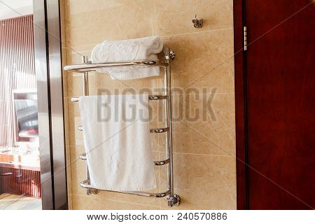 Modern Heated Towel Rail On Tiled Bathroom Wall.