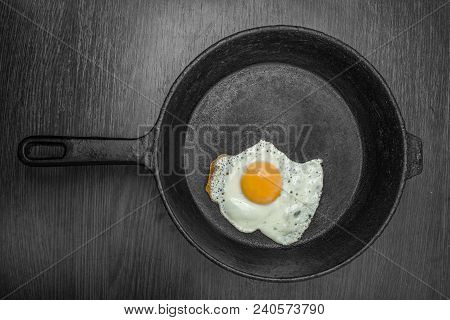 Frying Pan With Fried Eggs On A Wooden Dark Background