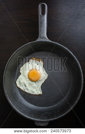 Frying Pan With Fried Eggs On A Wooden Dark Background