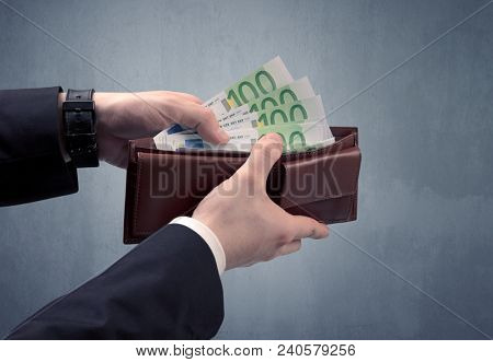 Businessman's hand in suit takes out eruo from his wallet