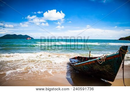 Lonely Boat Stands On The Shore Of The Azure Ocean In Thailand In The Summer