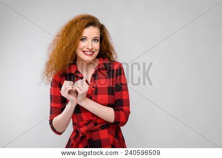 Charming Young Girl In A Checkered Cloth On A Gray Background