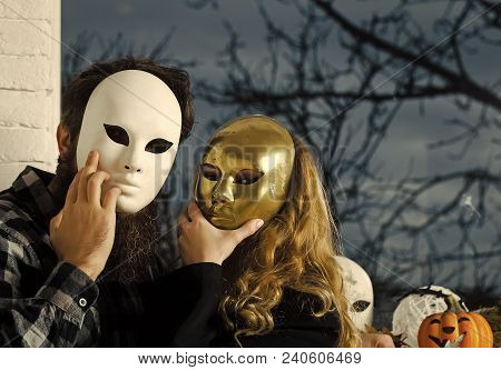 Girl And Man Hide Face With Masque. Woman With Long Blond Hair And Bearded Hipster In Mask At Window