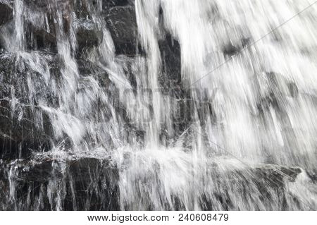 Water Cascading Over Jagged Rocks And Ice