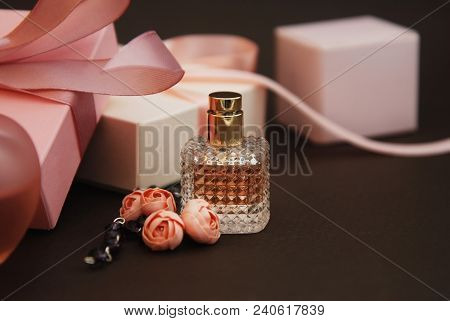 Women's Pink Perfume In Beautiful Bottle And Artificialt Flowers Bracelet On Brown Background With G