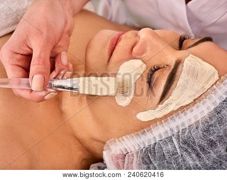 Collagen face mask. Facial skin treatment. Face of woman of elderly woman 50-60 years old receiving cosmetic procedure in beauty salon close up. Cream from age spots. Removing wrinkles.