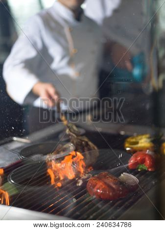 Master chef cooking delicious grilled meat steak with vegetables on a barbecue