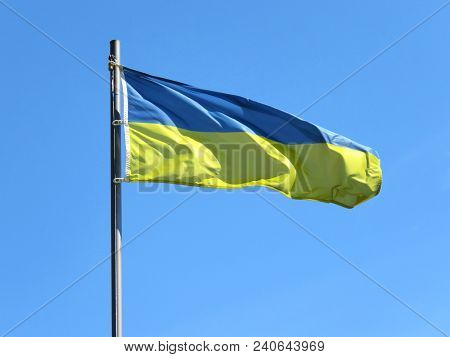 National Flag Of Ukraine On A Flagpole In Front Of Blue Sky.