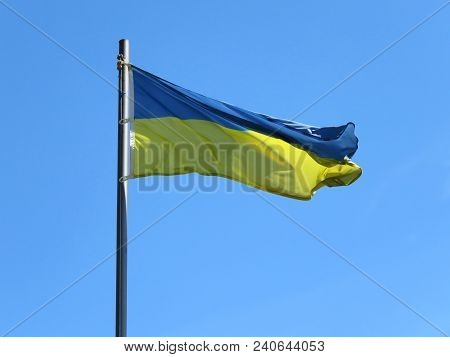 National Flag Of Ukraine On A Flagpole In Front Of Blue Sky.